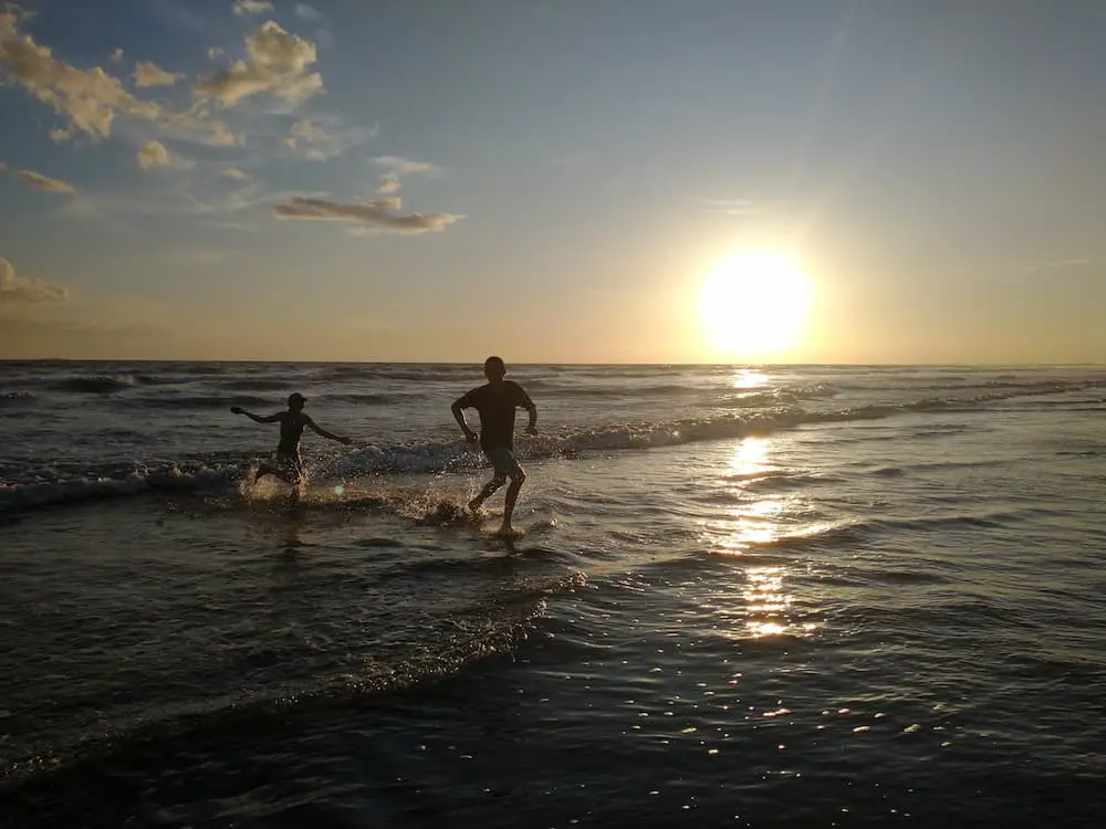 3 Popular Panama Beach Resorts - Show Pony Resort - Faith and Jim Playing in the Ocean at Sunset